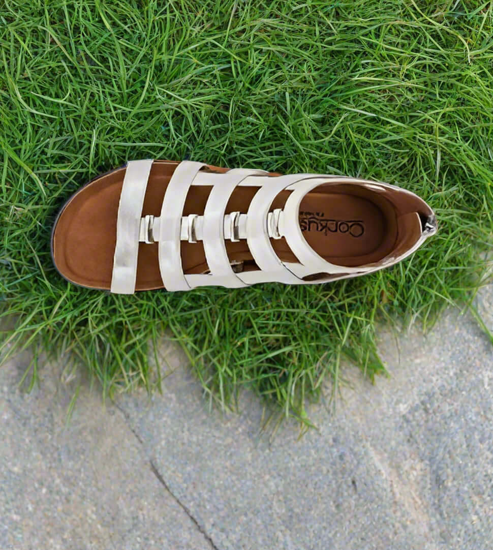 Corkys Caged Wedge Sandals in silver with faux leather straps on grass background, showcasing modern gladiator style.