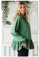 Green ADVENTURE AWAITS Hoodie by Cotton Bleu with eyelet ruffle hem, worn by model in a cozy, stylish oversized fit.