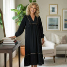 GRACEFUL INSTINCTS MAXI DRESS model showcasing black collared smocked detail maxi with leopard trim in a stylish setting.
