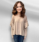 Neutral tan Soft Landing Top with double ruffle detail and mineral wash color, worn by a woman with wavy brown hair.