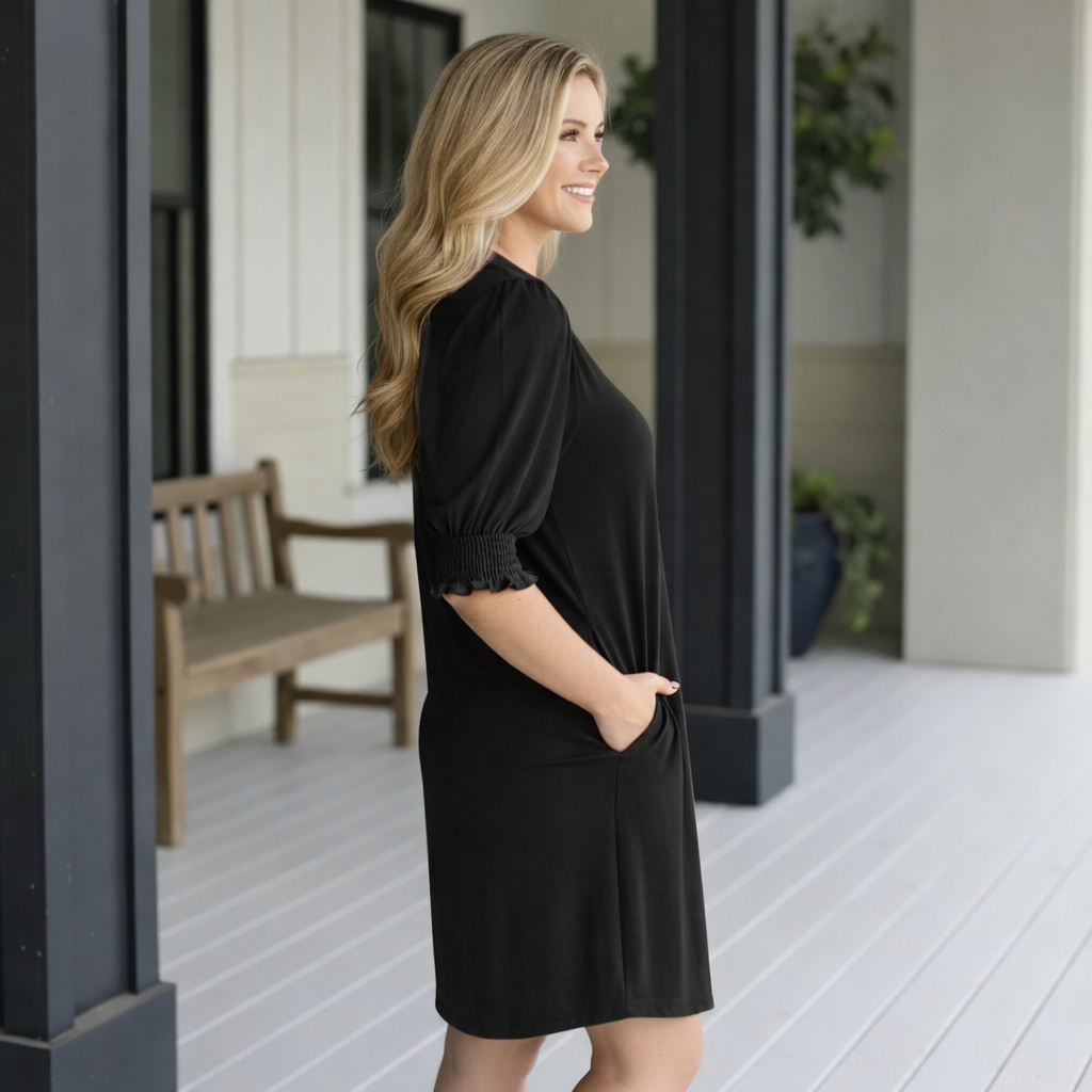 Woman smiling in a black HELLO BEAUTIFUL DRESS- Dear Scarlett, showcasing its chic style and comfortable design.