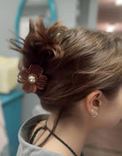 Woman wearing Petal Perfect Hair Clip in Mocha, styled in an elegant updo, showcasing its delicate floral design and pearl center.