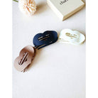 LOVE YOU MORE HAIR CLIPS in three colors: black, cream, and brown on a neutral surface.