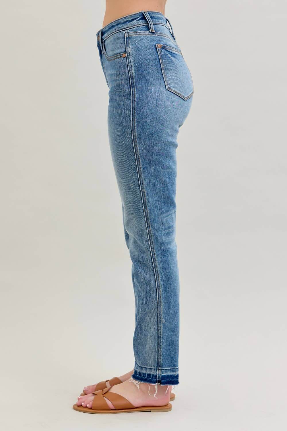 Profile view of JUDY BLUE - AVERY JEANS showcasing mid-rise fit and release hem detail.