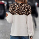 Chic Instincts Top featuring white waffle knit fabric and leopard print patchwork design, perfect for this weather.