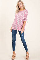 Soft mauve striped top with relaxed fit, paired with skinny jeans and heels, perfect for casual outings.