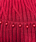 Dark red cable knit beanie with scarlet red pearls accent, showcasing elegant texture and design.