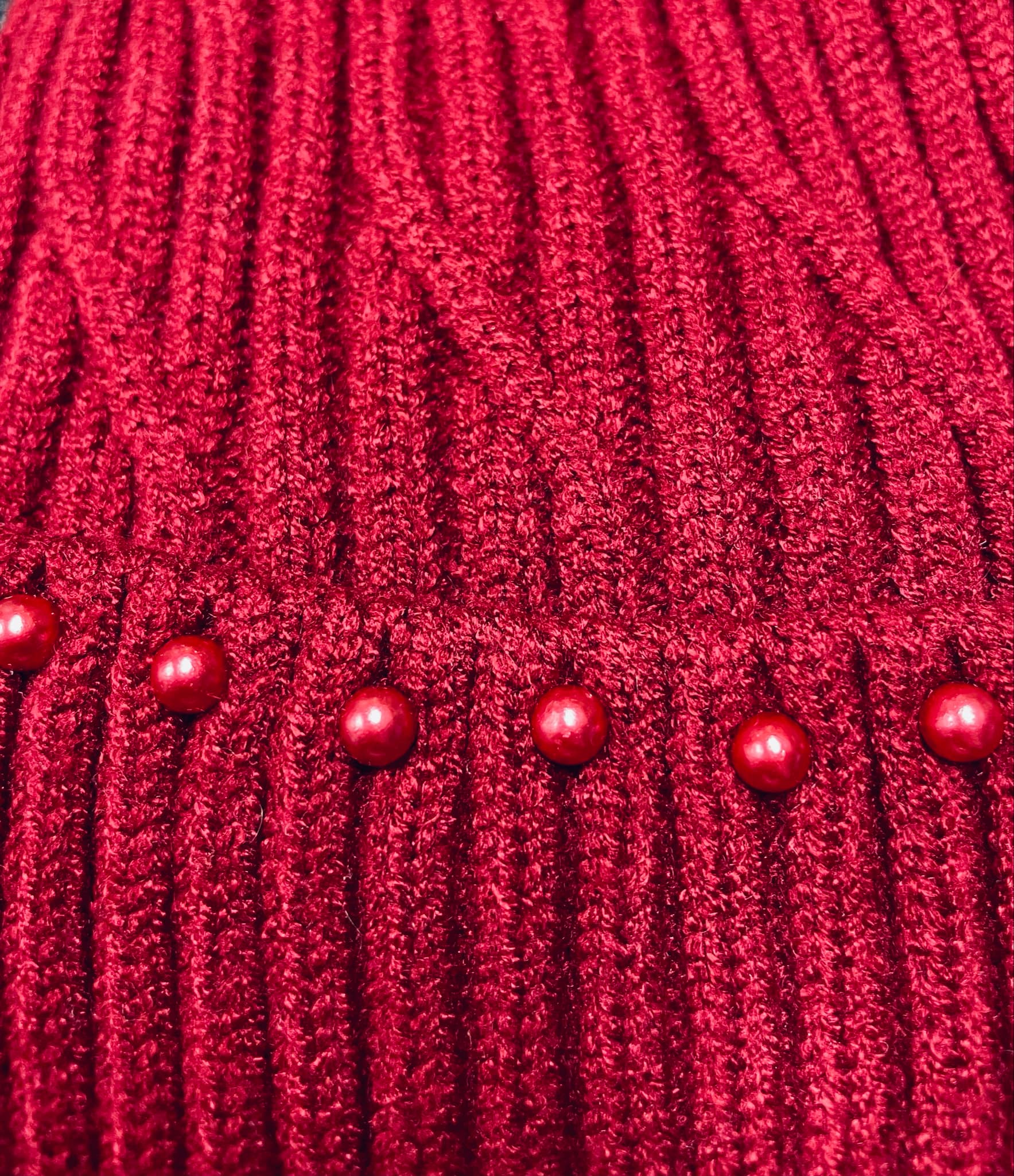 Dark red cable knit beanie with scarlet red pearls accent, showcasing elegant texture and design.