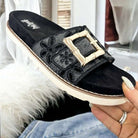 Corkys Slide in My DM's black sandals with eyelet strap and oversized bamboo buckle, perfect for summer comfort.