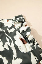 Close-up of flutter sleeve detail on a forest-green floral dress with contrasting prints.