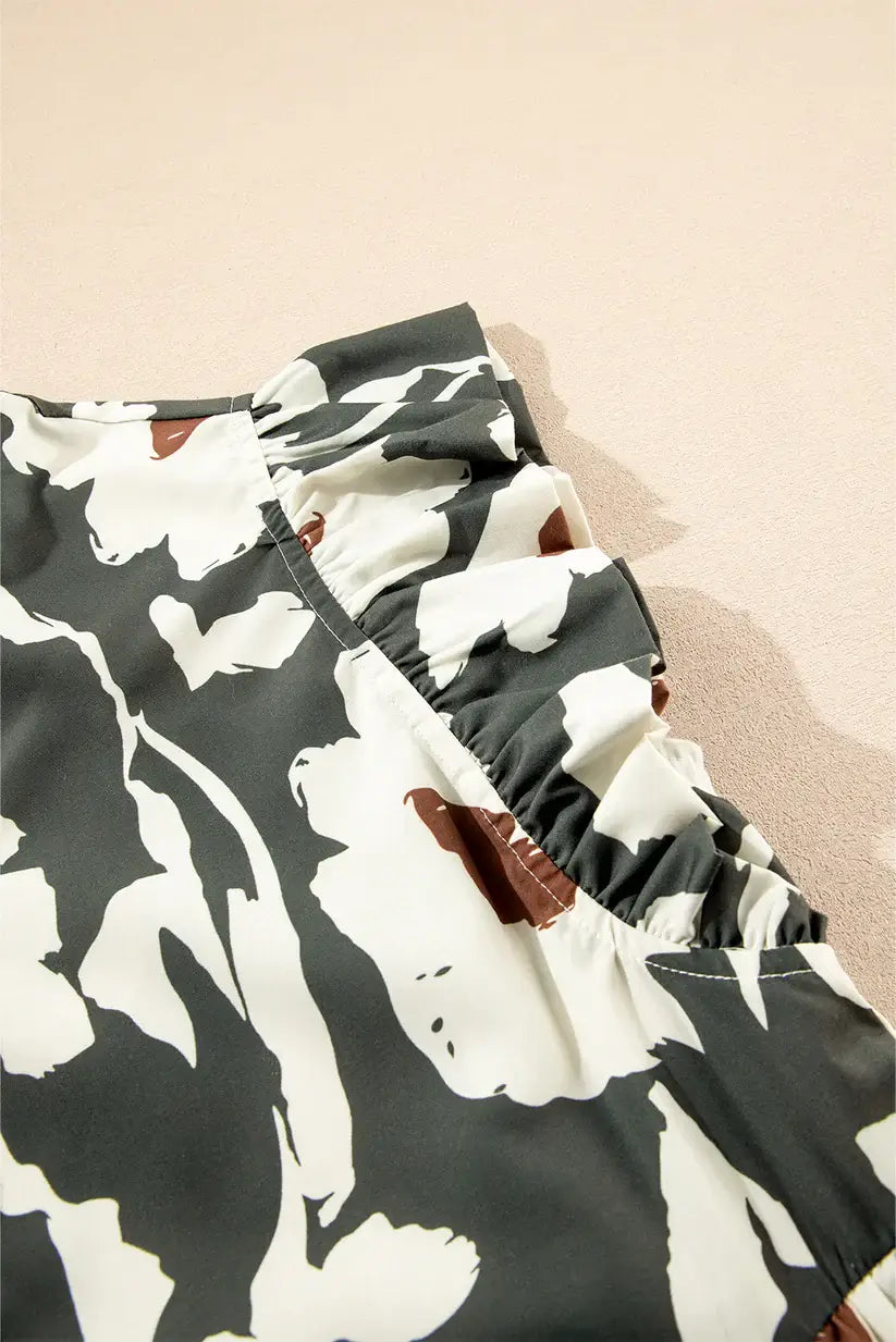 Close-up of flutter sleeve detail on a forest-green floral dress with contrasting prints.