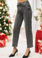 High rise straight leg acid wash black jeans with frayed hem, showcased against a festive backdrop.