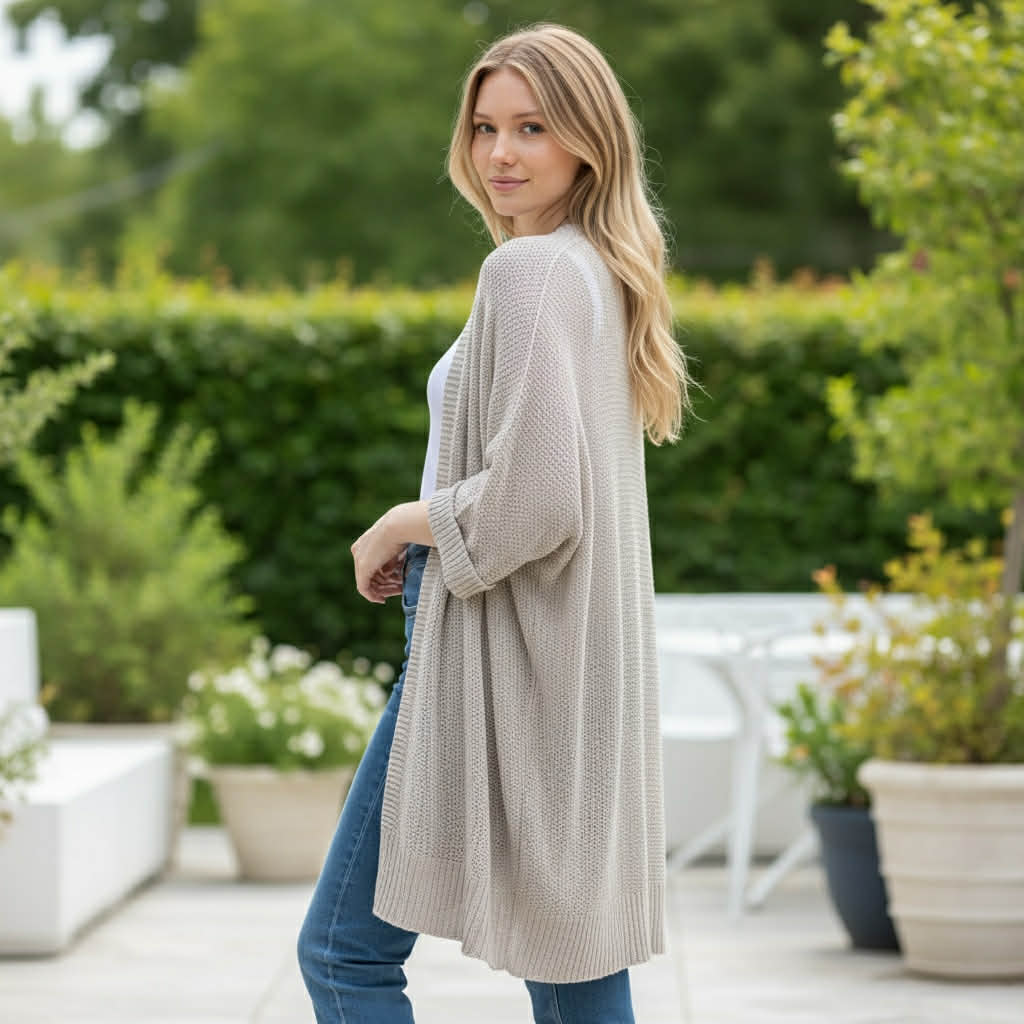 A woman wearing the BAREFOOT MORNINGS CARDIGAN, showcasing its relaxed fit and cozy knit texture in an outdoor setting.