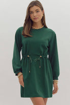 Woman wearing a dark green EVERGREEN BREEZE dress with drawstring waist and side pockets, by Entro.