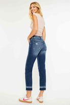 Woman wearing Kancan Georgia Ultra High Rise Slim Straight Leg Jeans in dark wash with subtle distressing.