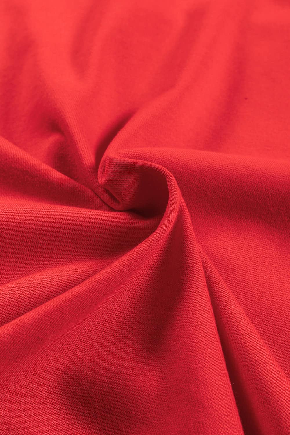 Close-up of vibrant red fabric with soft, smooth texture ideal for a cozy holiday sweatshirt.