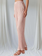 Blush pink plisse Soft Touch pants by Sugarlips, featuring a high waist and frilled bottom, styled with elegant heels.