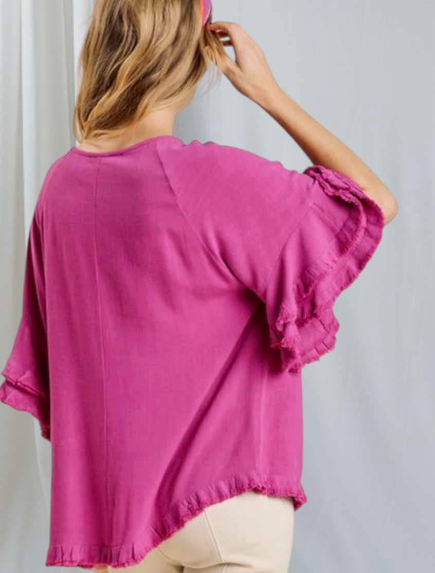 Back view of Umgee Endless Grace top in magenta with layered ruffle sleeves and a hi-low hem.