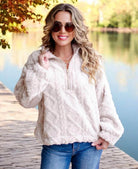 Woman wearing Very J Teddy Bear Sherpa fleece pullover with cable pattern, standing outdoors by a lake.