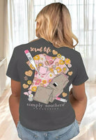 Woman wearing Simply Southern Scrub Life tee with colorful scrub design and healthcare motifs, perfect for professionals.