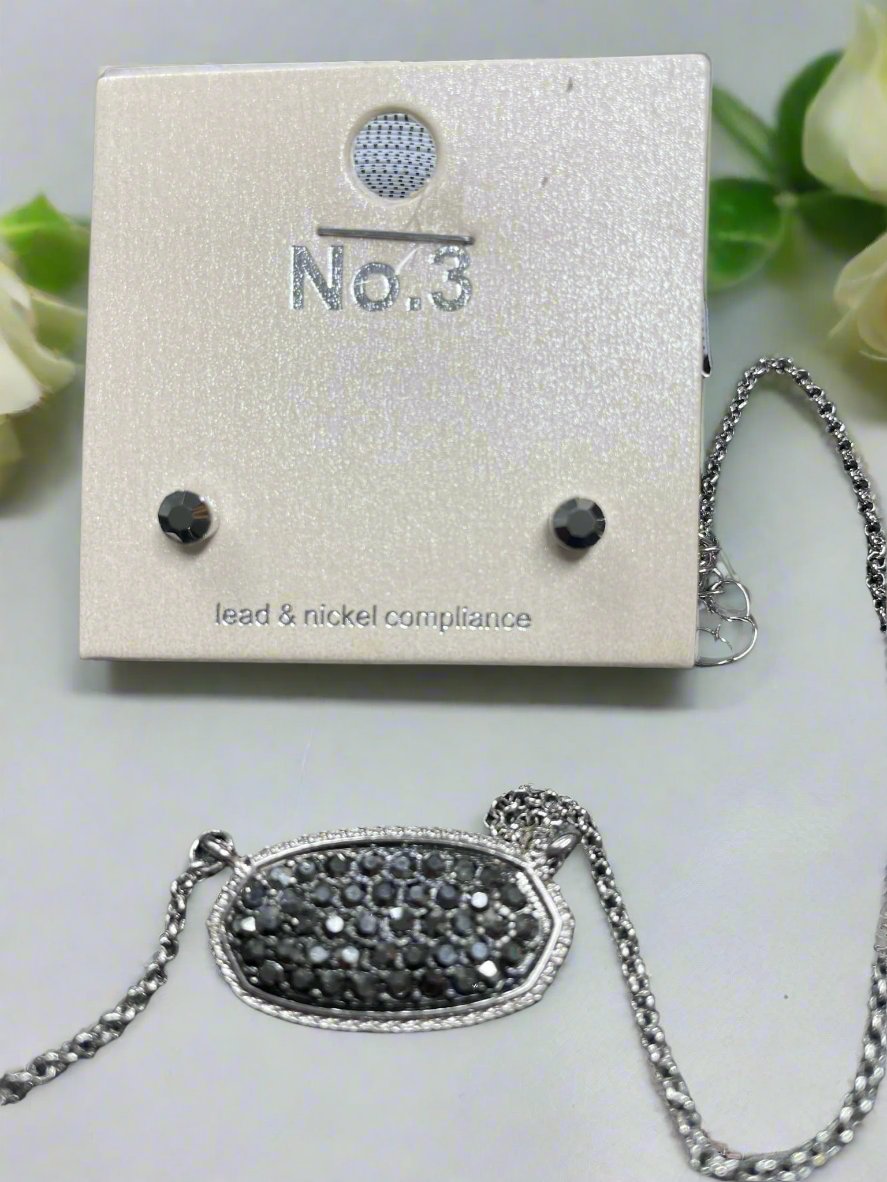 Druzy oval pendant and stud earrings set on display with silver chain and earring card, showcasing elegance and style.