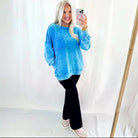 Model wearing OCEAN MIST PULLOVER in blue mineral wash with a pocket, styled with black pants.