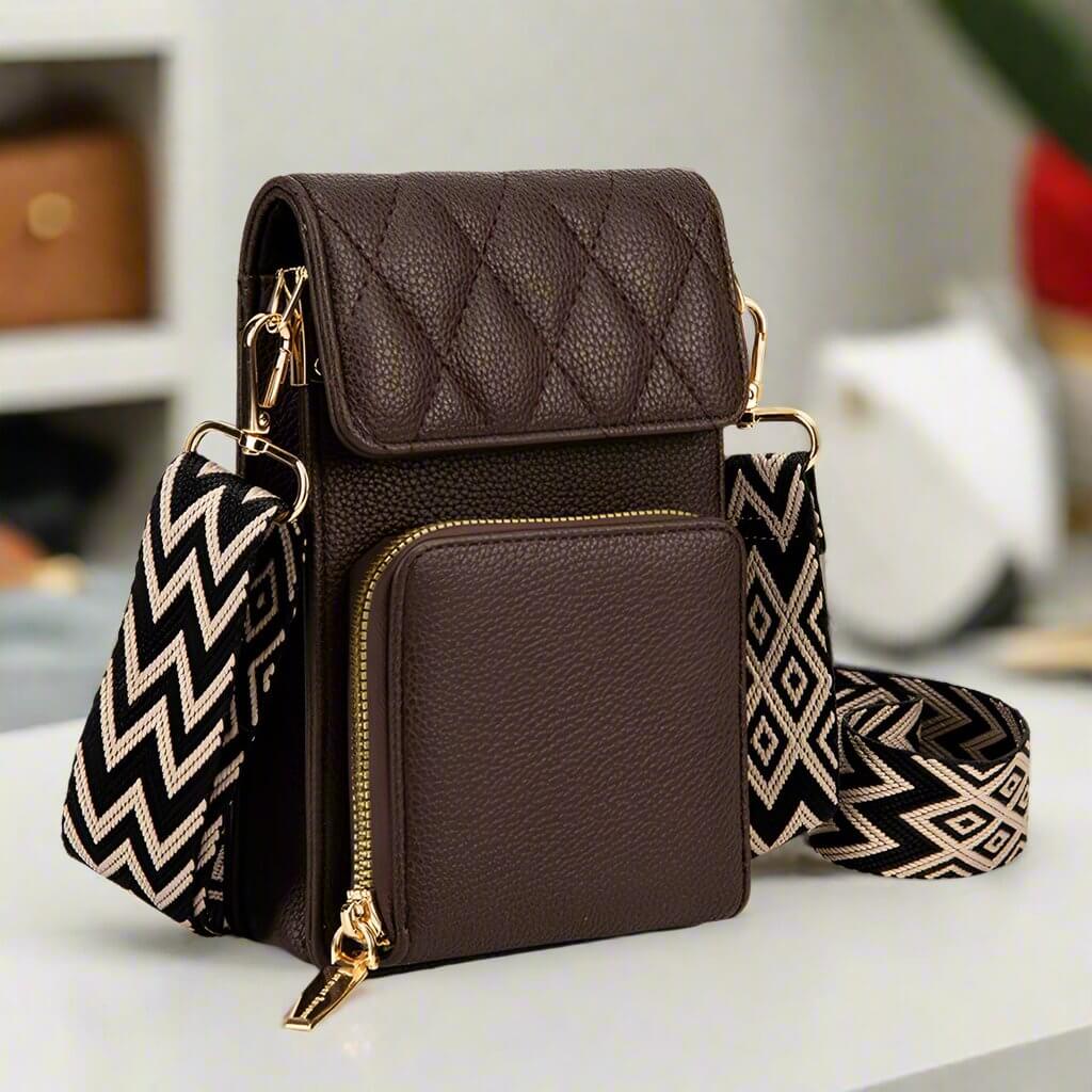 Vegan leather crossbody bag in chocolate with quilted design and chevron guitar strap, featuring gold zippers and ample storage.