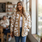 A model wearing a HONEY BLOSSOM SHERPA JACKET with a floral pattern, showcasing its cozy design in a stylish setting.