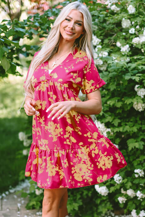 Model in a flowy TWIRL COMPANY DRESS featuring vibrant floral print, batwing sleeves, and flattering empire waist design.