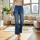 Model wearing ALIZA JEANS by Risen, high-rise flare patch pocket denim in a stylish living room setting.