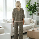 Woman wearing GROUNDED GRACE 2 pc Lounge Set in khaki jacquard leopard print, seen from behind in a modern living room.