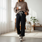 Comfort Culture Pants (Black) with leopard drawstring, cozy fleece lining worn with oversized sweater.