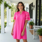 Kersten Ric Rac Dress, Hot Pink worn by a woman, showcasing layered ruffle sleeves on a sunny porch.