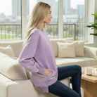 Model wearing the SOFT HORIZONS CREWNECK in lavender, showcasing its high/low fit and pockets.