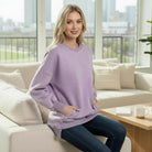 Model wearing SOFT HORIZONS CREWNECK in lavender, fleece lined pullover with pockets, high/low fit, stylish and cozy.