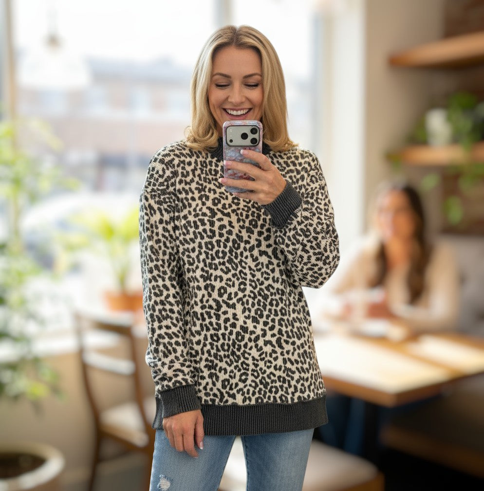 Smiling woman wearing THE PERFECT SPOT Ribbed Top in snow leopard print, showcasing cozy chic style.