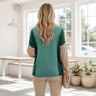 Back view of a woman wearing the EVERYDAY BALANCE TOP, showcasing its jade corded colorblock design.
