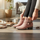 VERY G CAROLINA ANKLE BOOT worn by a person in a cozy living room setting with soft blush suede and stylish side buckle.