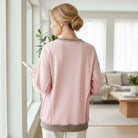 Model wearing the FROM THE HEART PULLOVER in light pink, showcasing its cozy design and relaxed fit.