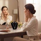 LOVE STORY Earrings and Necklace Set (silver) displayed on a jewelry stand with a woman trying on the earrings at a vanity.