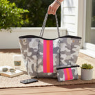 HUNTRESS LUXE 2 PIECE BAG SET featuring a grey camo tote and matching pouch on a sunny patio.