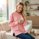 Woman in soft pink SOFT INTENTIONS Pullover by Zenana, holding a coffee mug in a cozy setting.