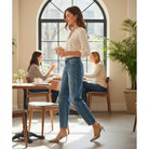 Woman wearing ELLA-KATE BARREL JEANS by Risen, sipping coffee in a stylish café setting.