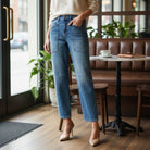 Model wearing ELLA-KATE BARREL JEANS by Risen in a casual café setting, highlighting wide barrel leg and patch pockets.