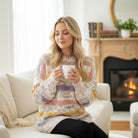 Model wearing EASY LIKE SUNDAY SWEATER while enjoying a cup of coffee in a cozy living room.