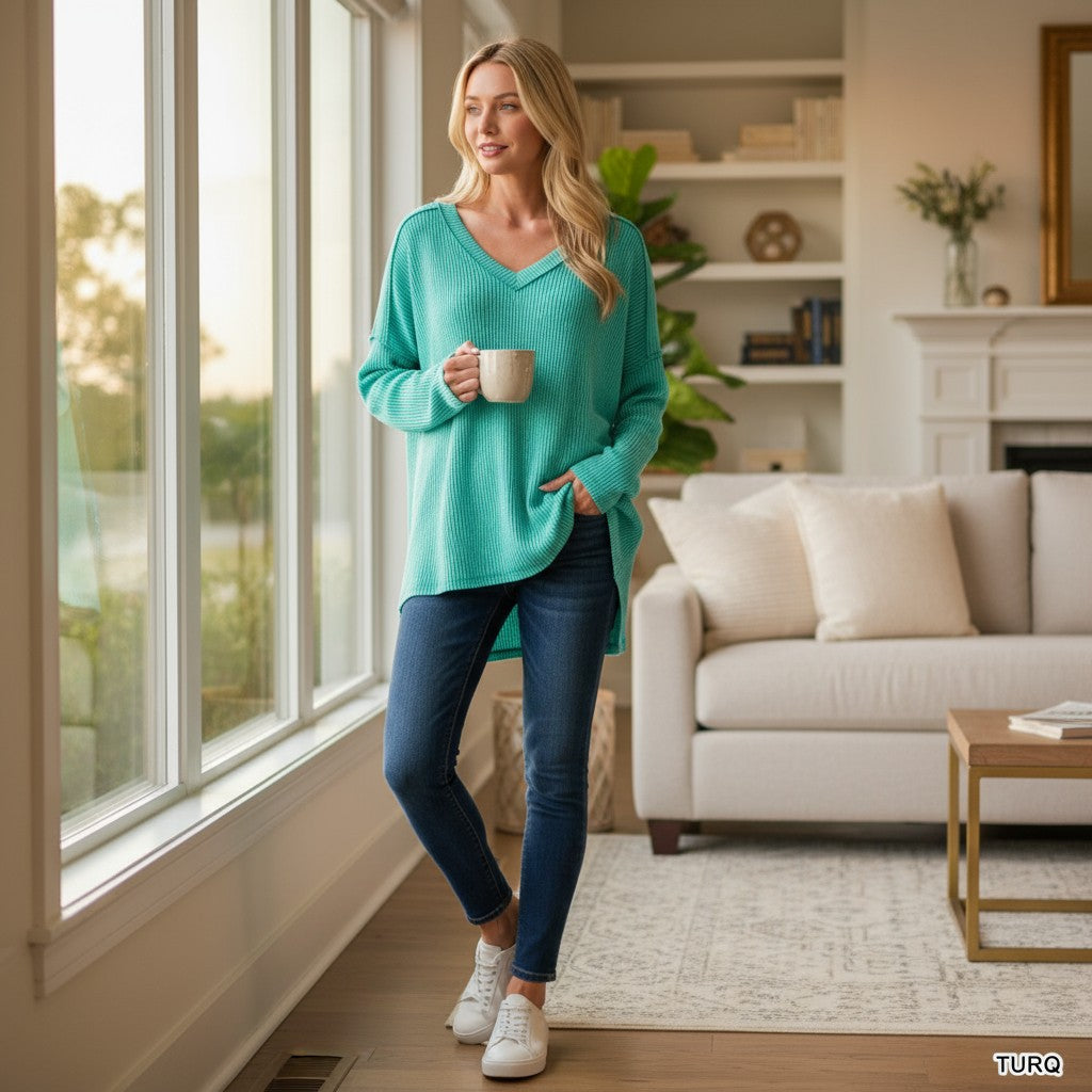 COZY CONCEPTS RIBBED TOP (turquoise) worn by a woman, showcasing relaxed style in a sunlit living room.