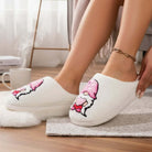 HUGS & HEARTS SLIPPERS featuring a cozy design, soft plush material, and adorable embroidered character in pink.
