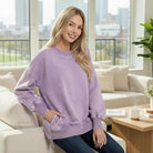 Model wearing the SOFT HORIZONS CREWNECK in lavender, showcasing its soft material and comfy fit while sitting indoors.