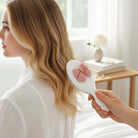 BOW BLISS MINI HAIRBRUSH being used to style hair, showcasing its cute 3D bow design and practical air-cushion base.