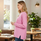 Woman in a pink RELAX MODE TOP (taffy) holding a coffee cup in a cozy café.